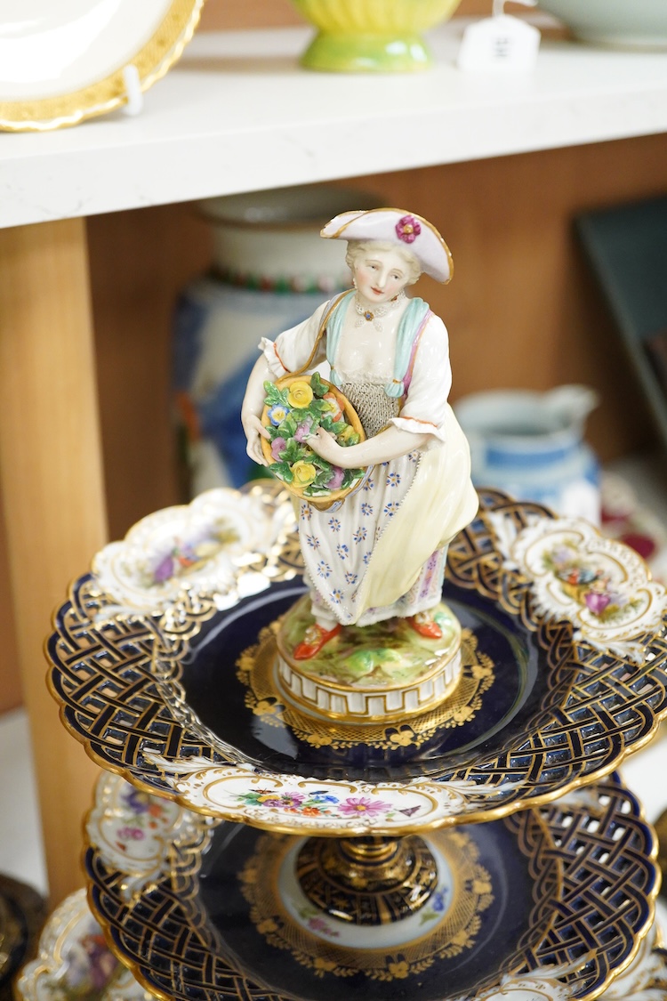 A pair of late 19th century Meissen three tier cake stands with figural tops, 48cm high